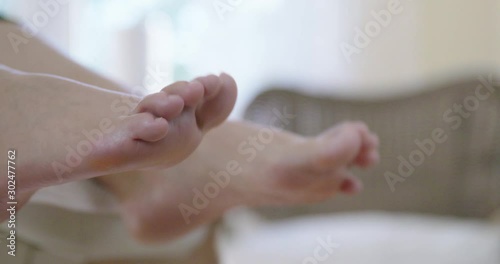 Customer in podiatric practice wiggles / taps her toes to create a sense of motion control. Movement therapy for feet, close up.