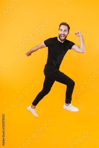 Full length image of caucasian man in basic clothes smiling and running
