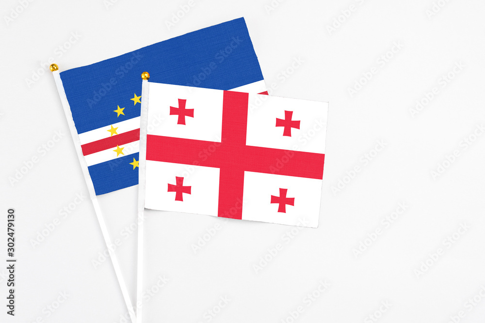 Georgia and Cape Verde stick flags on white background. High quality fabric, miniature national flag. Peaceful global concept.White floor for copy space.
