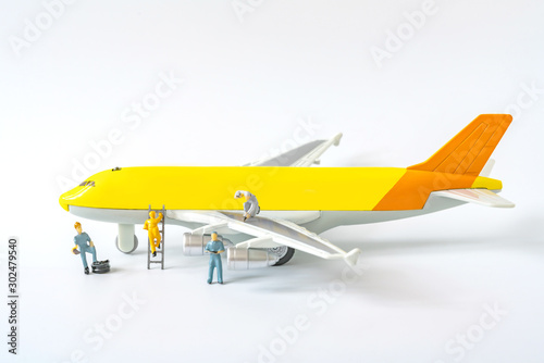 Close up miniature airplane and technicians maintenance and checking on white background.