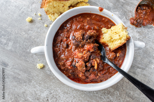 bowl of chili with black beans and cornbread flat lay photo