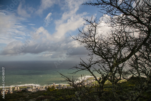 Blue sky with clouds over the coast of Cape Town. View from the foot of Table Mountain. The sky is in dark clouds. The shore of the city of Cape Town from the mountain. South Africa