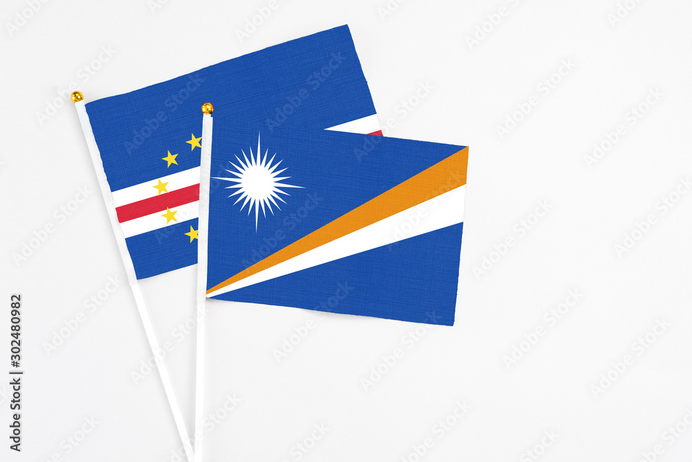 Marshall Islands and Cape Verde stick flags on white background. High quality fabric, miniature national flag. Peaceful global concept.White floor for copy space. Marshall Islands and Cape Verde stick flags on white background. High quality fabric, miniature national flag. Peaceful global concept.White floor for copy space.