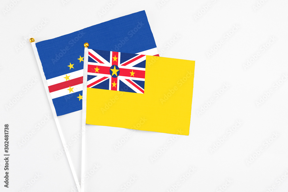 Niue and Cape Verde stick flags on white background. High quality fabric, miniature national flag. Peaceful global concept.White floor for copy space. Niue and Cape Verde stick flags on white background. High quality fabric, miniature national flag. Peaceful global concept.White floor for copy space.