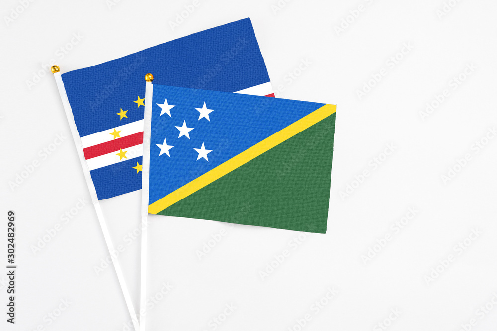 Solomon Islands and Cape Verde stick flags on white background. High quality fabric, miniature national flag. Peaceful global concept.White floor for copy space.