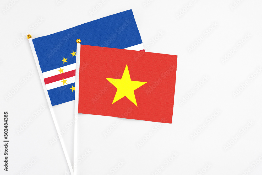 Vietnam and Cape Verde stick flags on white background. High quality fabric, miniature national flag. Peaceful global concept.White floor for copy space. Vietnam and Cape Verde stick flags on white background. High quality fabric, miniature national flag. Peaceful global concept.White floor for copy space.
