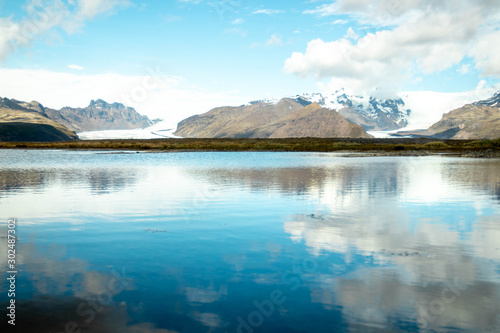 View of two glaciers in the mountains and reflective lake along the ring road of Iceland's east coast