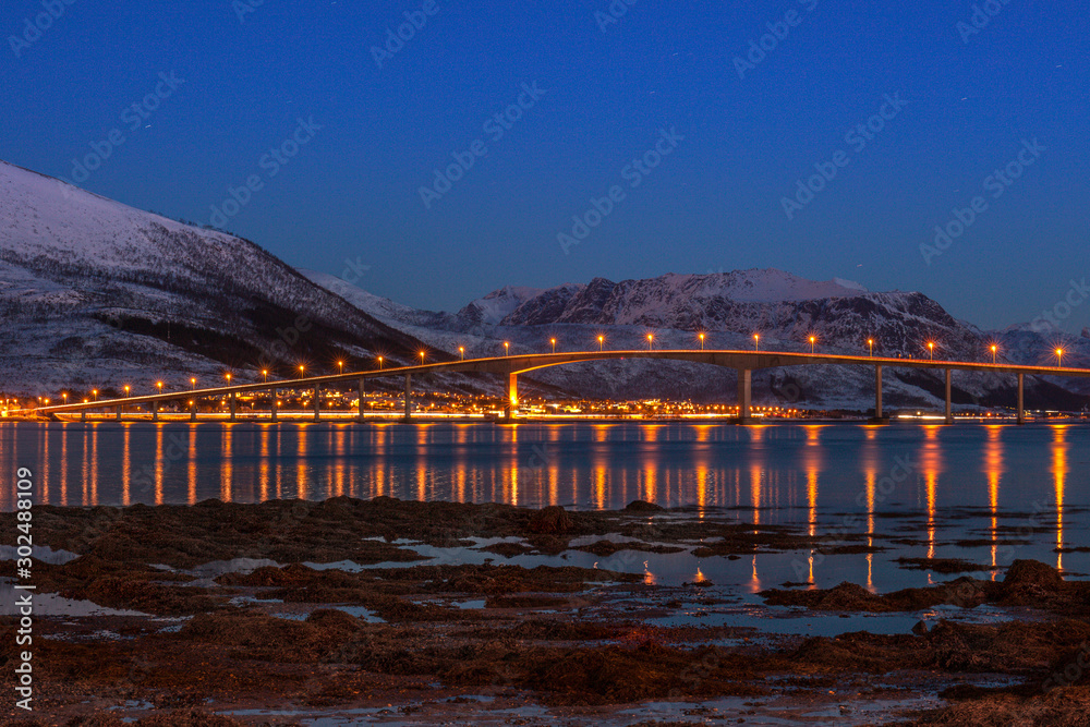 Amazing bridge with beautiful reflection in water in blue hour, star tracks, Lofoten islands, Norway.