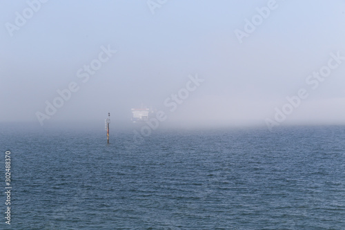 Ferry emerging out of sea mist on the Solent near the Isle of Wight and Portsmouth, Hampshire, UK