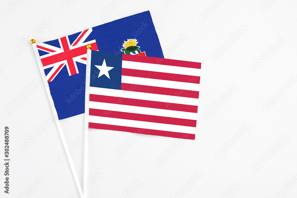 Liberia and Cayman Islands stick flags on white background. High quality fabric, miniature national flag. Peaceful global concept.White floor for copy space. Liberia and Cayman Islands stick flags on white background. High quality fabric, miniature national flag. Peaceful global concept.White floor for copy space.