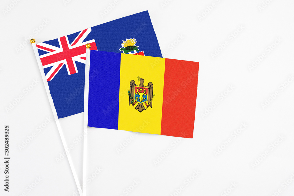 Moldova and Cayman Islands stick flags on white background. High quality fabric, miniature national flag. Peaceful global concept.White floor for copy space. Moldova and Cayman Islands stick flags on white background. High quality fabric, miniature national flag. Peaceful global concept.White floor for copy space.