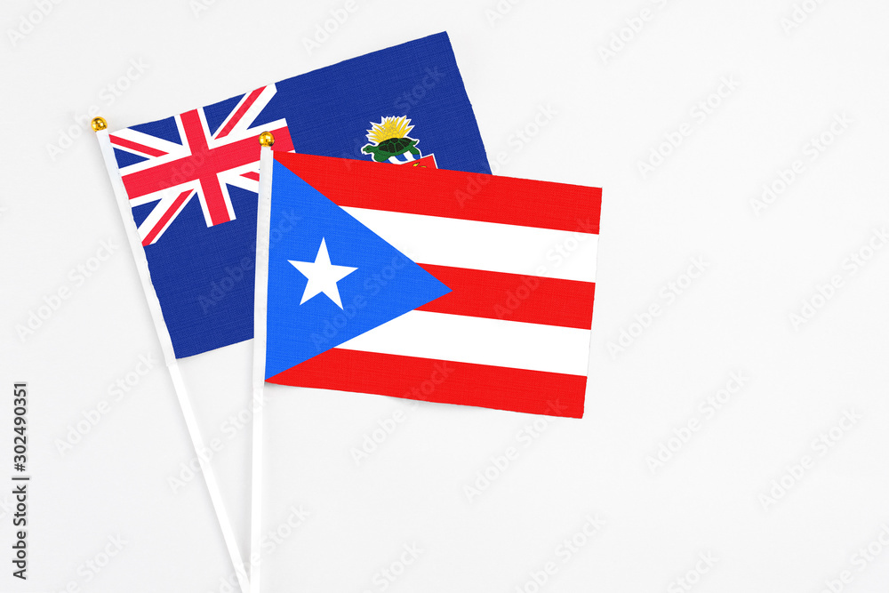Puerto Rico and Cayman Islands stick flags on white background. High quality fabric, miniature national flag. Peaceful global concept.White floor for copy space. Puerto Rico and Cayman Islands stick flags on white background. High quality fabric, miniature national flag. Peaceful global concept.White floor for copy space.