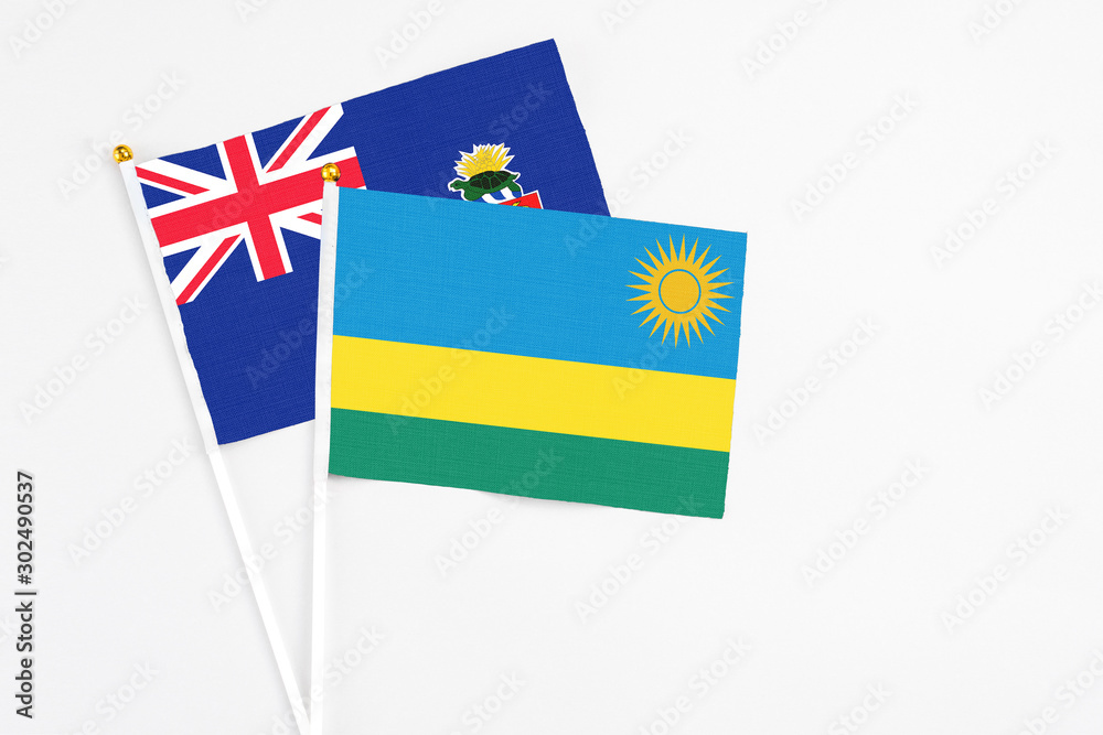 Rwanda and Cayman Islands stick flags on white background. High quality fabric, miniature national flag. Peaceful global concept.White floor for copy space. Rwanda and Cayman Islands stick flags on white background. High quality fabric, miniature national flag. Peaceful global concept.White floor for copy space.