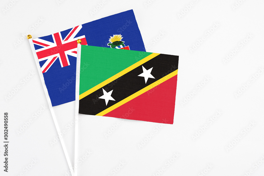 Saint Kitts And Nevis and Cayman Islands stick flags on white background. High quality fabric, miniature national flag. Peaceful global concept.White floor for copy space. Saint Kitts And Nevis and Cayman Islands stick flags on white background. High quality fabric, miniature national flag. Peaceful global concept.White floor for copy space.