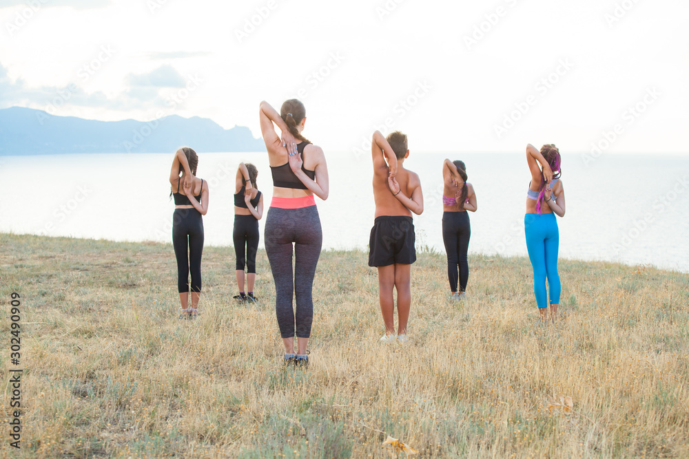 Instructor trains yoga kids in the mountains on the ocean. Instructor trains yoga kids in the mountains on the ocean.