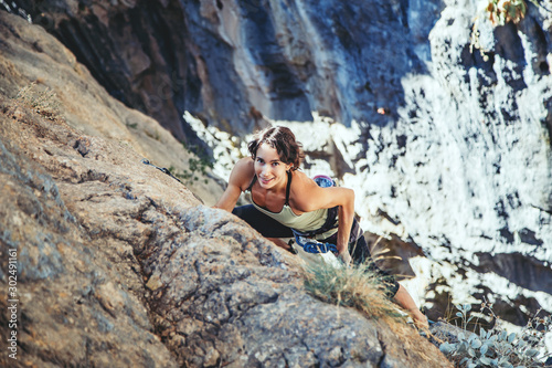 Woman climbs a rock.