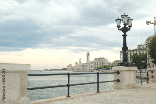 Promenade of Bari with the buildings of the Murattiano village. A parapet and a street lamp on the road that runs along the sea.