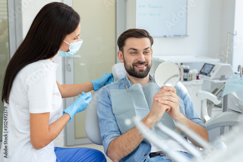 Male patient looking at teeth in the mirror