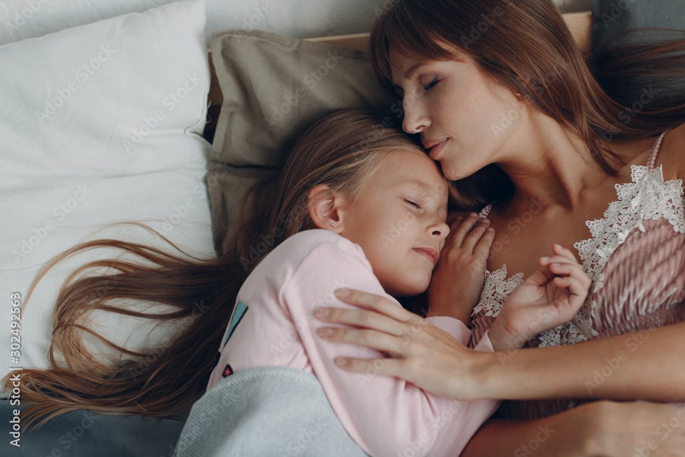 Mother sleep hugging with little daughter girl. Family and mother's day concept. Mother sleep hugging with little daughter girl. Family and mother's day concept.