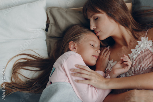 Mother sleep hugging with little daughter girl. Family and mother's day concept.