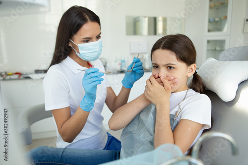 small patient is afraid of dentist in modern dental clinic