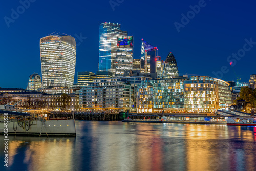 London Evening cityscape with a museum boat and skyscrapers