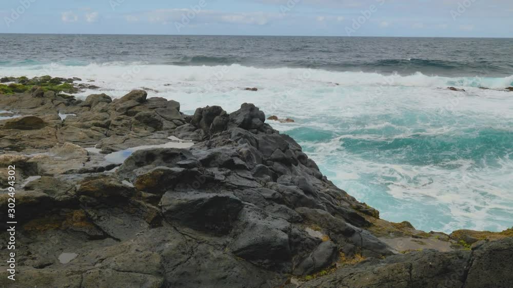 Handheld shot of the waves hitting the rocky beach on an overcast day Handheld shot of the waves hitting the rocky beach on an overcast day