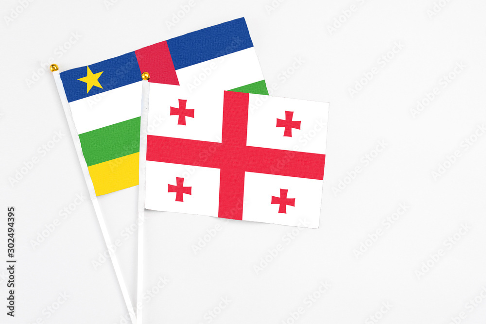 Georgia and Central African Republic stick flags on white background. High quality fabric, miniature national flag. Peaceful global concept.White floor for copy space.