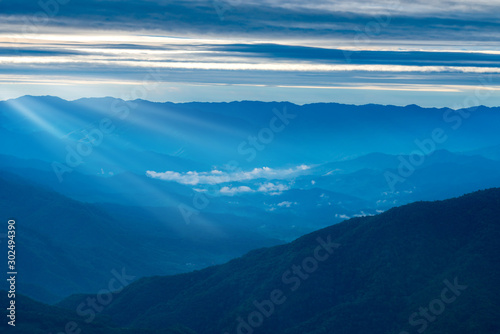 Beautiful Landscape of mountain layer in morning sun ray and green forest.The sunrise shines down the green forest mountain in Thailand.