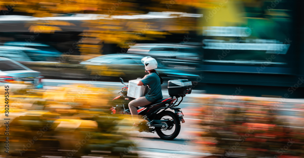 Motociclista con un brazo transportando productos con una moto