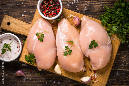 Chicken fillet with ingredients for cooking on wooden table. photo