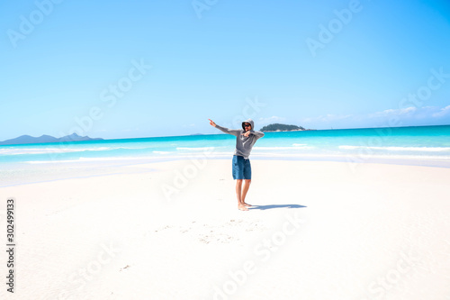 Guy fooling around in front of view toward Esk Island at Whitehaven Beach, Whitsundays, Queensland, Australia © Jarrod