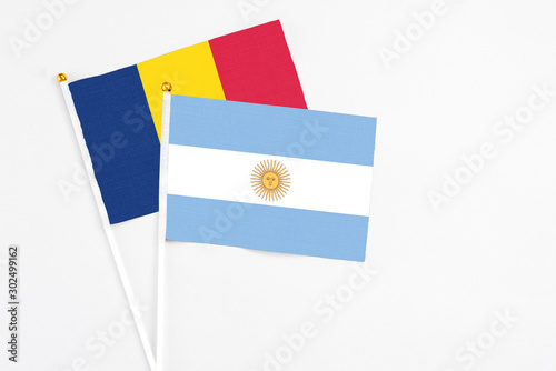 Argentina and Chad stick flags on white background. High quality fabric, miniature national flag. Peaceful global concept.White floor for copy space. photo