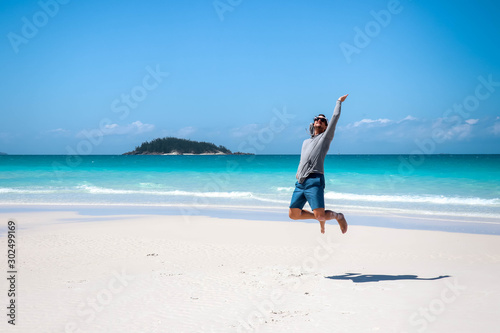 Canvas Print Guy jumping in on the Whitehaven Beach in front of Esk Island, Whitsundays, Quee