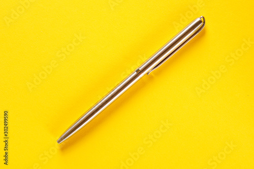 metal pen isolated on yellow background