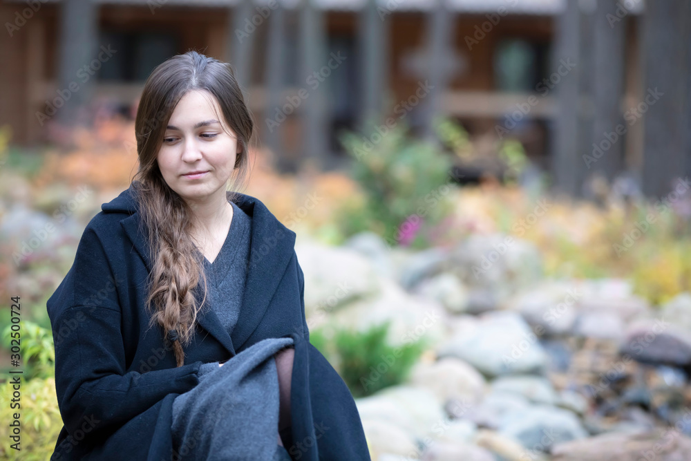 Sad girl in nature. Portrait of a sad young woman.