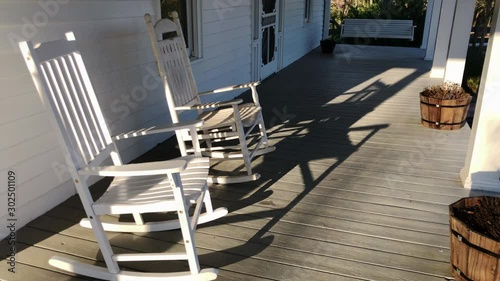 An empty rocking chair on a country porch in the evening.