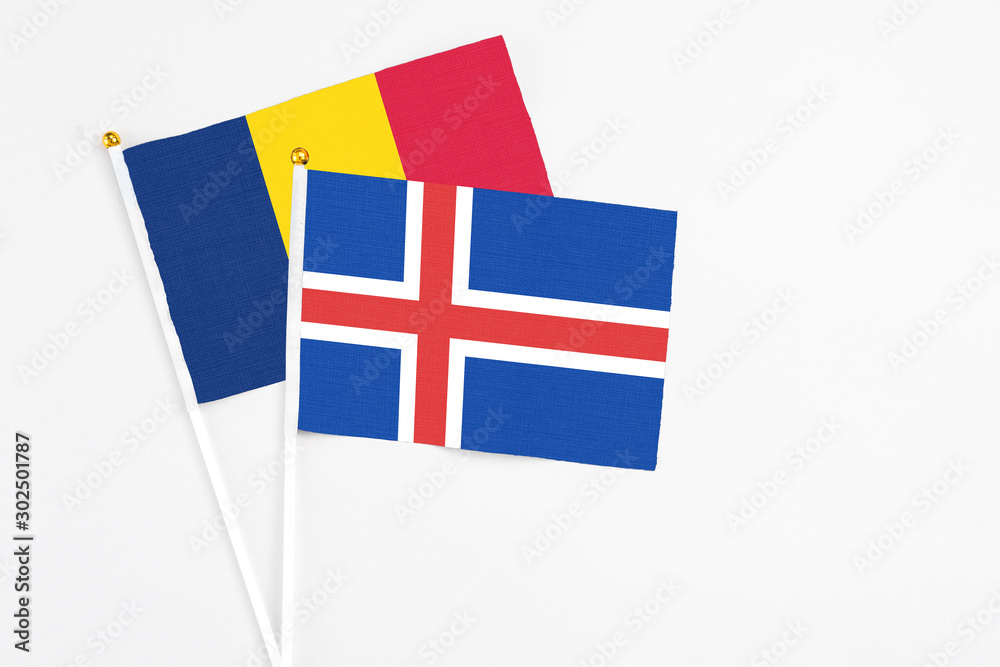 Iceland and Chad stick flags on white background. High quality fabric, miniature national flag. Peaceful global concept.White floor for copy space.