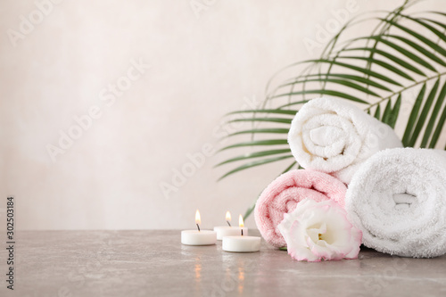 Slika na platnu Towels, candles and flower on grey background, space for text