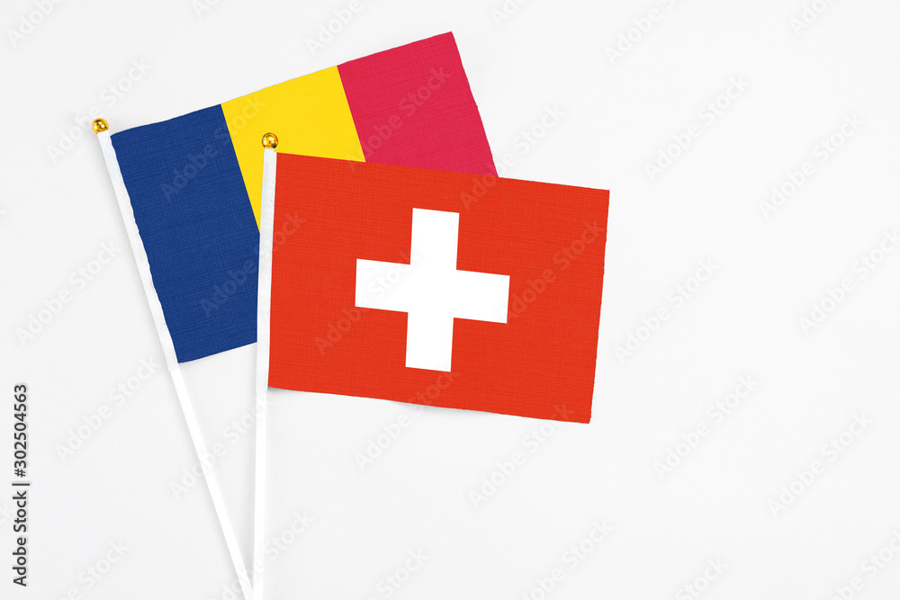Switzerland and Chad stick flags on white background. High quality fabric, miniature national flag. Peaceful global concept.White floor for copy space.