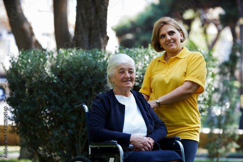 Professional helpful caregiver and handicapped senior woman. © Gecko Studio