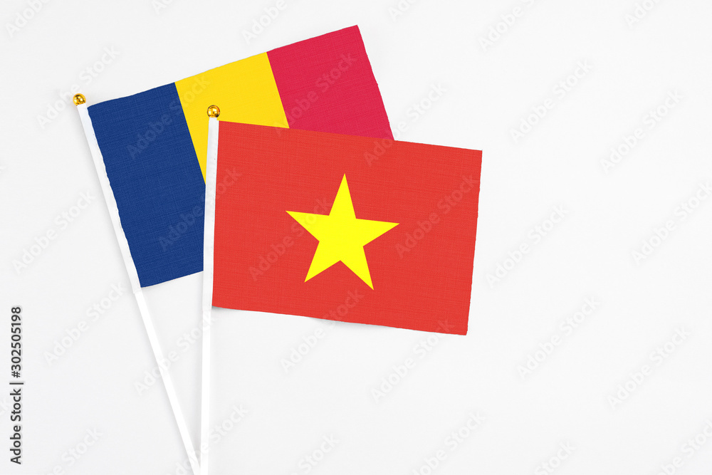Vietnam and Chad stick flags on white background. High quality fabric, miniature national flag. Peaceful global concept.White floor for copy space. Vietnam and Chad stick flags on white background. High quality fabric, miniature national flag. Peaceful global concept.White floor for copy space.