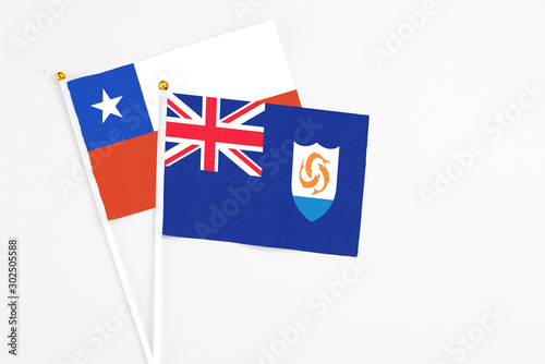 Anguilla and Chile stick flags on white background. High quality fabric, miniature national flag. Peaceful global concept.White floor for copy space.