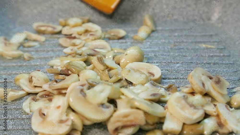 Champignon mushrooms are fried in a pan in oil. Champignon mushrooms are fried in a pan in oil.