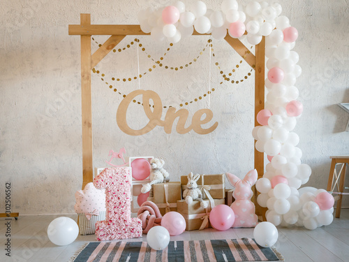 Birthday decorations - gifts, toys, balloons, garland and number for little  baby party on a white wall background. Stock Photo