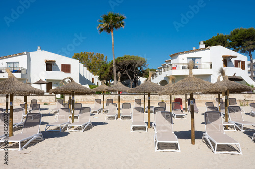 Straw umbrellas on the beach in the resort town of Port Alcudia on the island of Mallorca