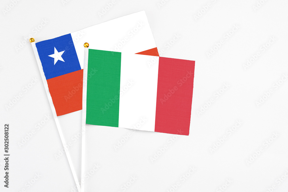 Fototapeta premium Italy and Chile stick flags on white background. High quality fabric, miniature national flag. Peaceful global concept.White floor for copy space.