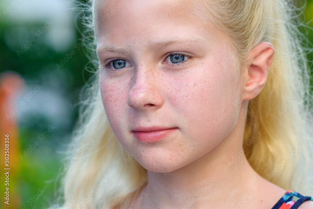 Beautiful little blonde girl with long hair in the park, summer, portrait, smiling, emotion Beautiful little blonde girl with long hair in the park, summer, portrait, smiling, emotion