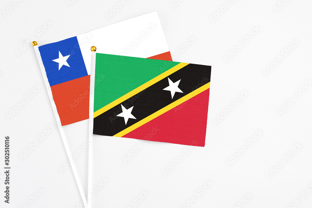 Saint Kitts And Nevis and Chile stick flags on white background. High quality fabric, miniature national flag. Peaceful global concept.White floor for copy space. Saint Kitts And Nevis and Chile stick flags on white background. High quality fabric, miniature national flag. Peaceful global concept.White floor for copy space.