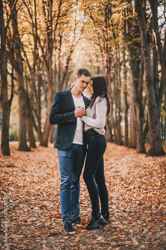 Beautiful young couple hugging in autumn park. © zadorozhna